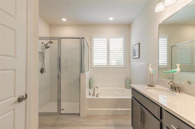 bathroom featuring vanity and separate shower and tub