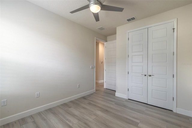 unfurnished bedroom featuring ceiling fan, light hardwood / wood-style floors, and a closet