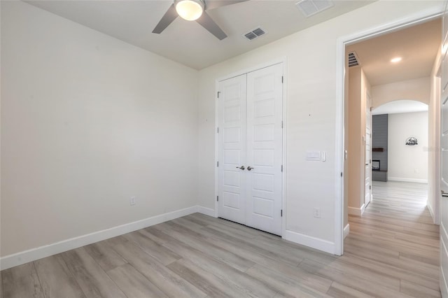 unfurnished bedroom featuring light hardwood / wood-style flooring, a closet, and ceiling fan