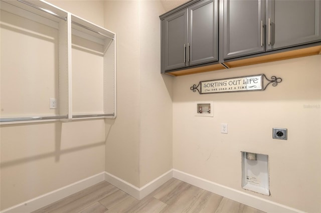 laundry area featuring hookup for a washing machine, electric dryer hookup, cabinets, and light hardwood / wood-style floors