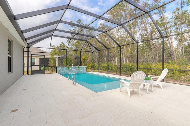 view of pool with a patio area, pool water feature, and glass enclosure