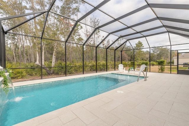 view of swimming pool featuring pool water feature, glass enclosure, and a patio area