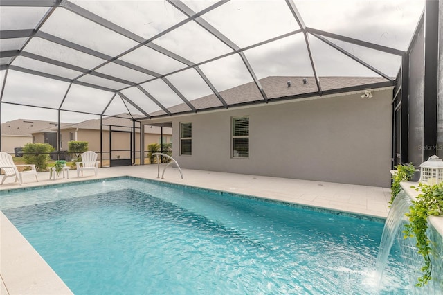 view of swimming pool featuring a patio area, pool water feature, and glass enclosure