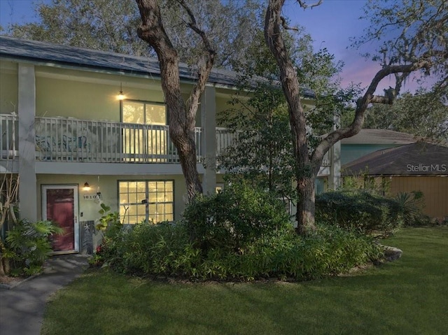 exterior space featuring a balcony and a lawn