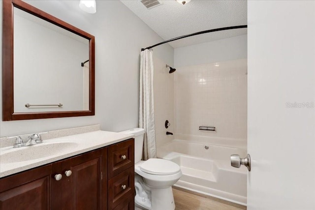 full bathroom featuring hardwood / wood-style floors, vanity, toilet, a textured ceiling, and shower / bath combo with shower curtain