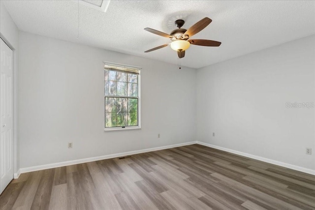 unfurnished room with ceiling fan, hardwood / wood-style flooring, and a textured ceiling