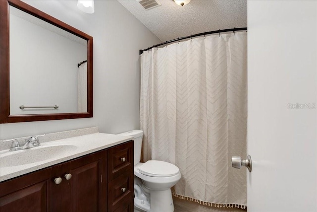 bathroom featuring vanity, toilet, and a textured ceiling