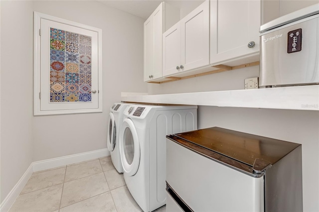 washroom featuring cabinets, washer and dryer, and light tile patterned floors