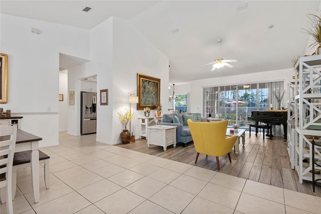 living room featuring light tile patterned flooring, ceiling fan, and high vaulted ceiling