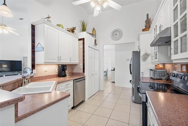 kitchen with sink, ceiling fan, appliances with stainless steel finishes, white cabinetry, and a towering ceiling