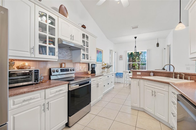 kitchen with sink, backsplash, stainless steel appliances, white cabinets, and decorative light fixtures