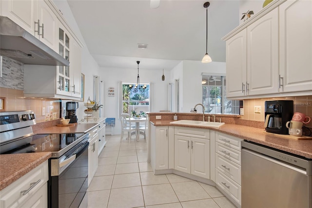 kitchen with light tile patterned flooring, sink, pendant lighting, stainless steel appliances, and white cabinets