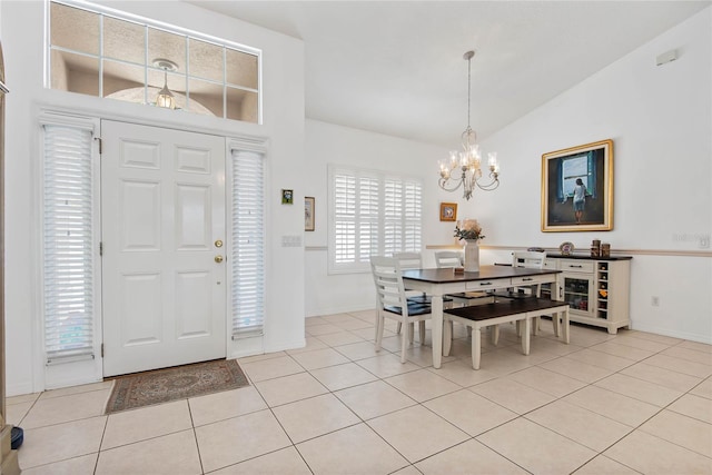 entryway with a notable chandelier, vaulted ceiling, and light tile patterned flooring