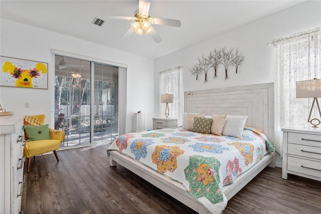 bedroom with access to exterior, dark hardwood / wood-style flooring, and multiple windows