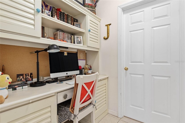 office featuring light tile patterned flooring and built in desk