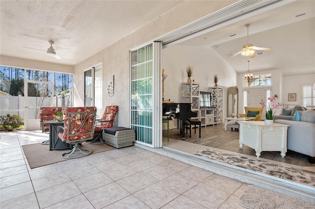 sunroom / solarium featuring lofted ceiling and ceiling fan with notable chandelier