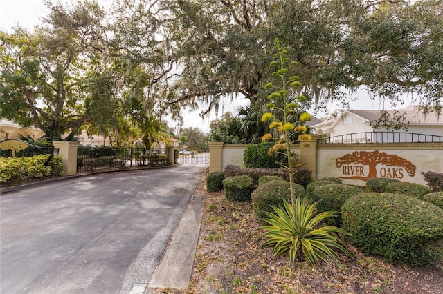 view of street featuring a gate, curbs, and a gated entry