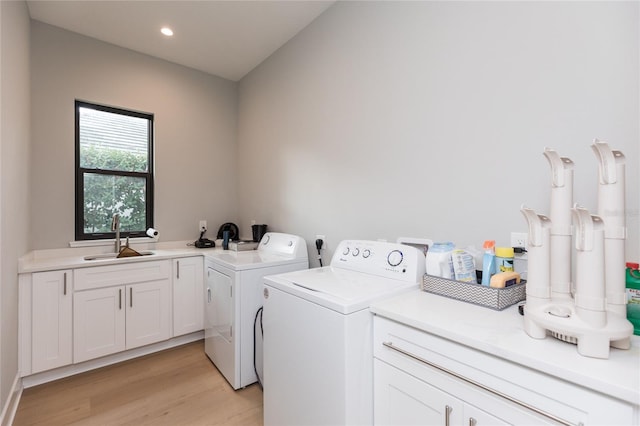 laundry area with light wood-style flooring, recessed lighting, a sink, cabinet space, and washing machine and clothes dryer