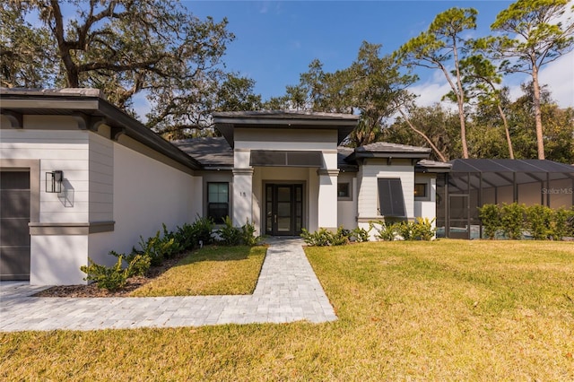 prairie-style house featuring a front yard, a lanai, and stucco siding