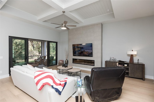 living room with baseboards, light wood-style floors, coffered ceiling, beamed ceiling, and ceiling fan