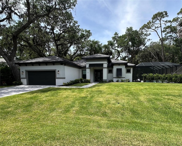 prairie-style home with stucco siding, driveway, a front lawn, and a garage