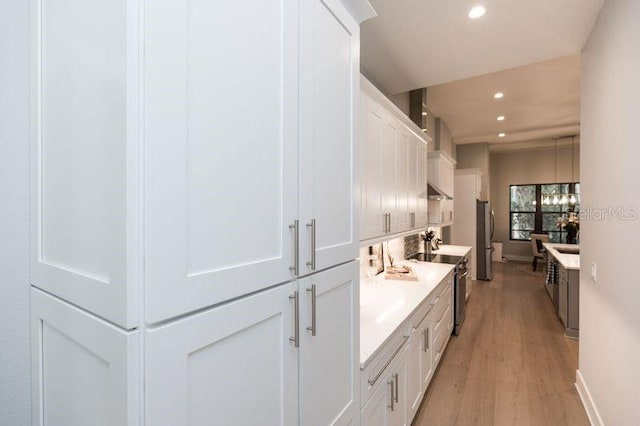 bathroom with baseboards, wood finished floors, and recessed lighting
