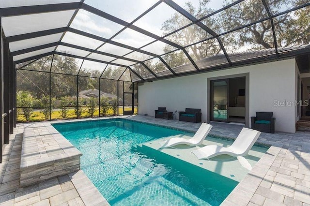 pool featuring glass enclosure and a patio