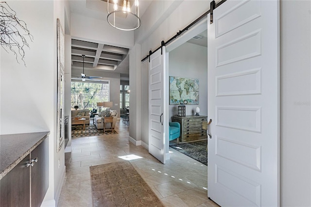 corridor with coffered ceiling, a barn door, and beam ceiling