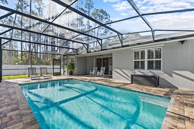 view of pool with a patio and glass enclosure