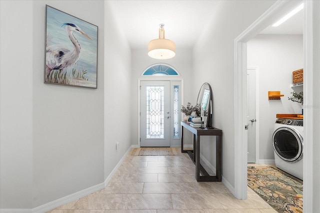 tiled entryway featuring washer / dryer