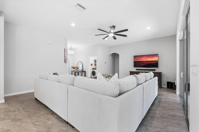 living room featuring ceiling fan and washer / dryer