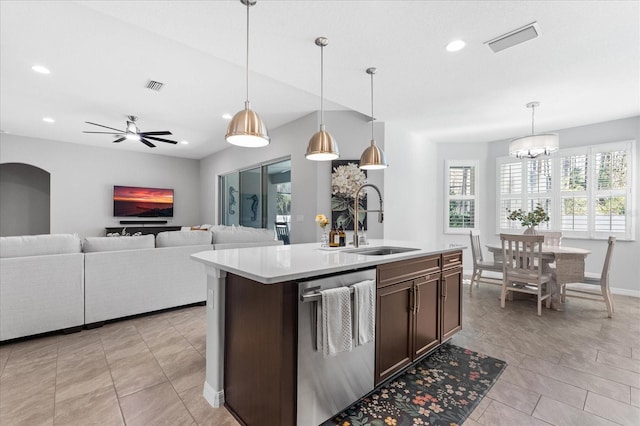 kitchen featuring a kitchen island with sink, sink, stainless steel dishwasher, and hanging light fixtures