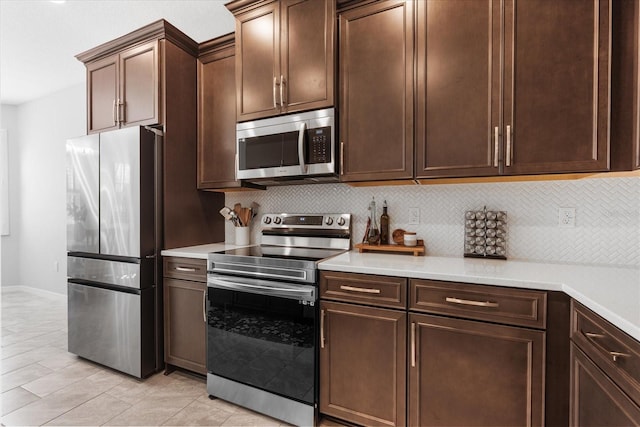 kitchen with tasteful backsplash, light tile patterned flooring, appliances with stainless steel finishes, and dark brown cabinets