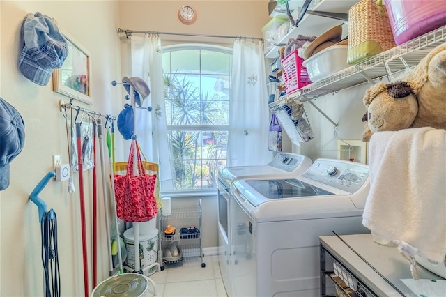 clothes washing area featuring light tile patterned flooring and washing machine and clothes dryer