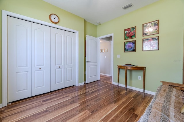 unfurnished bedroom with dark wood-type flooring and a closet