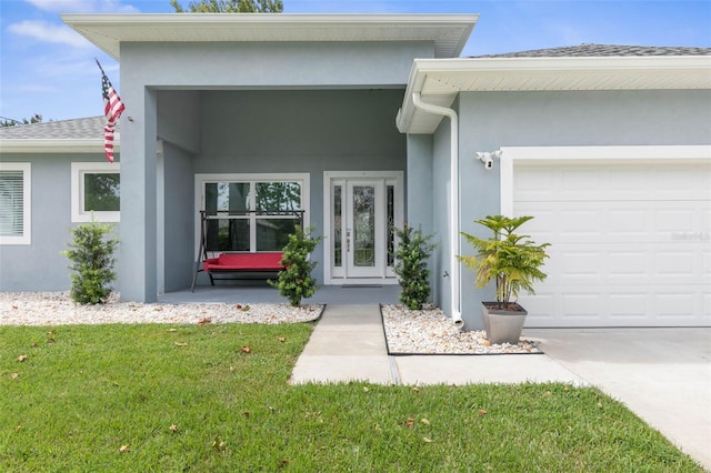 view of exterior entry featuring a garage and a lawn