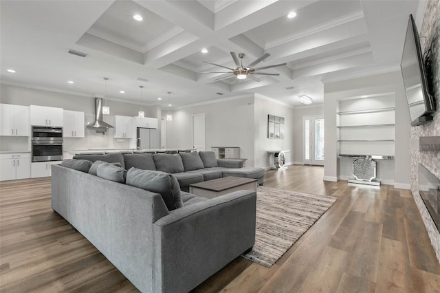 living room with beamed ceiling, hardwood / wood-style flooring, coffered ceiling, ceiling fan, and crown molding