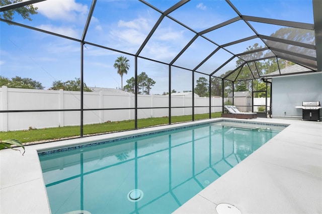 view of swimming pool featuring a grill, a lanai, a patio, and a storage unit