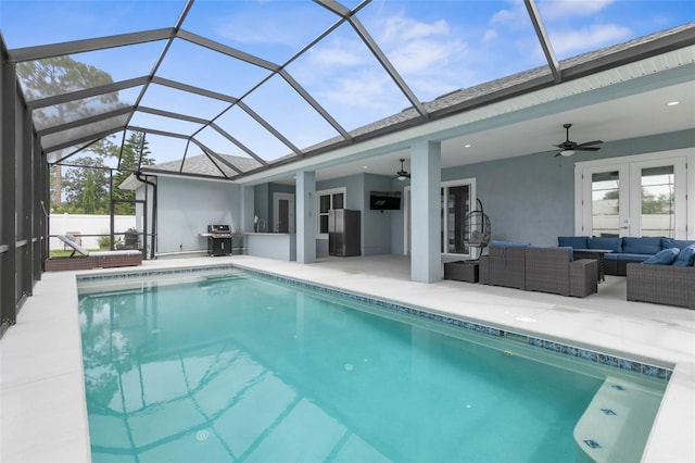 view of swimming pool with a lanai, ceiling fan, outdoor lounge area, a patio, and french doors