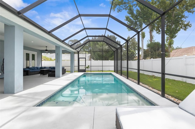 view of swimming pool with an outdoor living space, a patio, ceiling fan, and glass enclosure