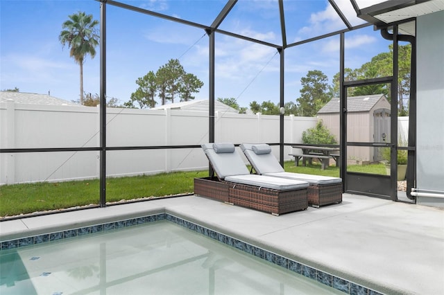 view of pool featuring a patio, glass enclosure, and a storage shed