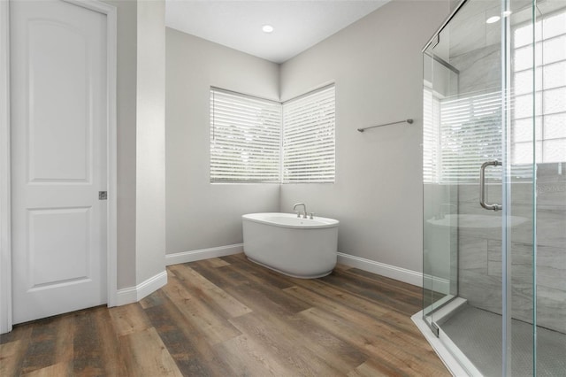 bathroom with hardwood / wood-style flooring and independent shower and bath