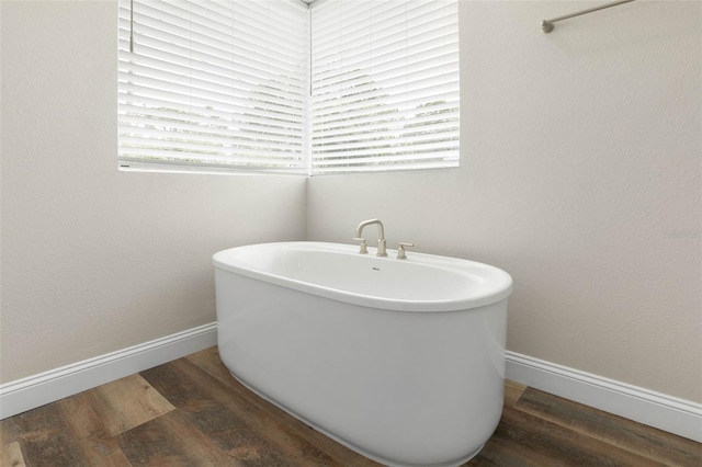 bathroom featuring hardwood / wood-style flooring, plenty of natural light, and a washtub