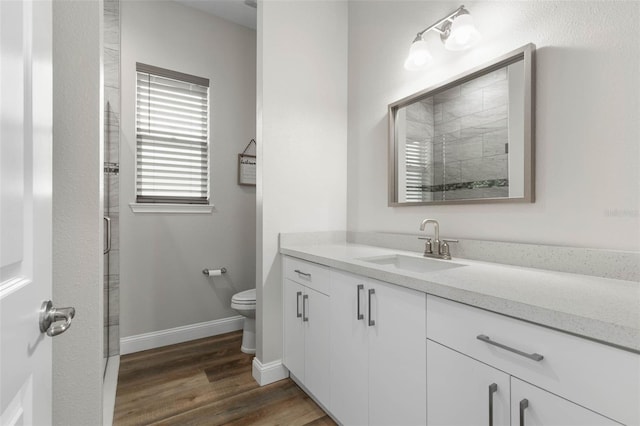 bathroom with vanity, toilet, and hardwood / wood-style floors