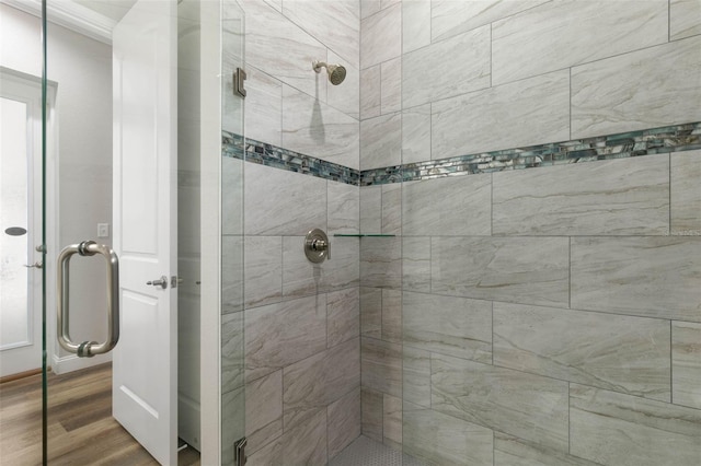 bathroom featuring hardwood / wood-style flooring and a shower with shower door