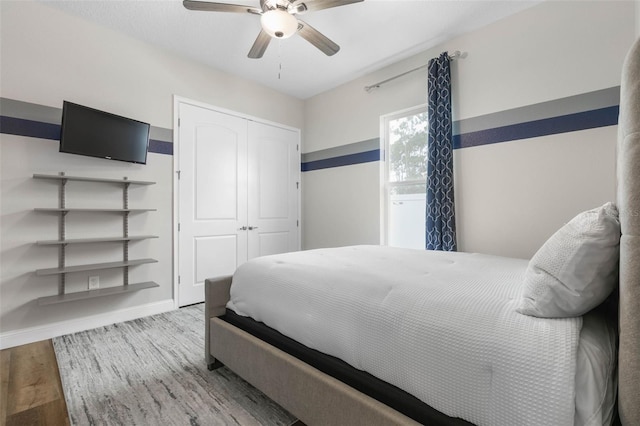 bedroom featuring light hardwood / wood-style flooring, ceiling fan, and a closet