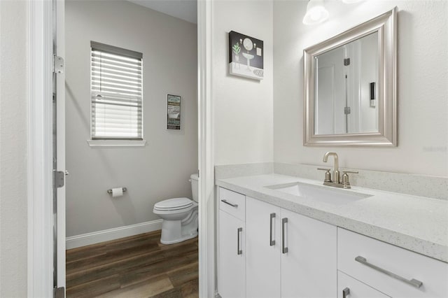 bathroom with hardwood / wood-style flooring, vanity, and toilet