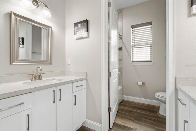 full bathroom with bathtub / shower combination, vanity, toilet, and wood-type flooring