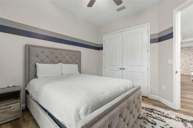 bedroom with ceiling fan, wood-type flooring, and a closet