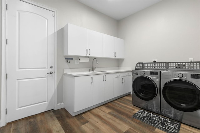 washroom featuring cabinets, separate washer and dryer, sink, and dark wood-type flooring